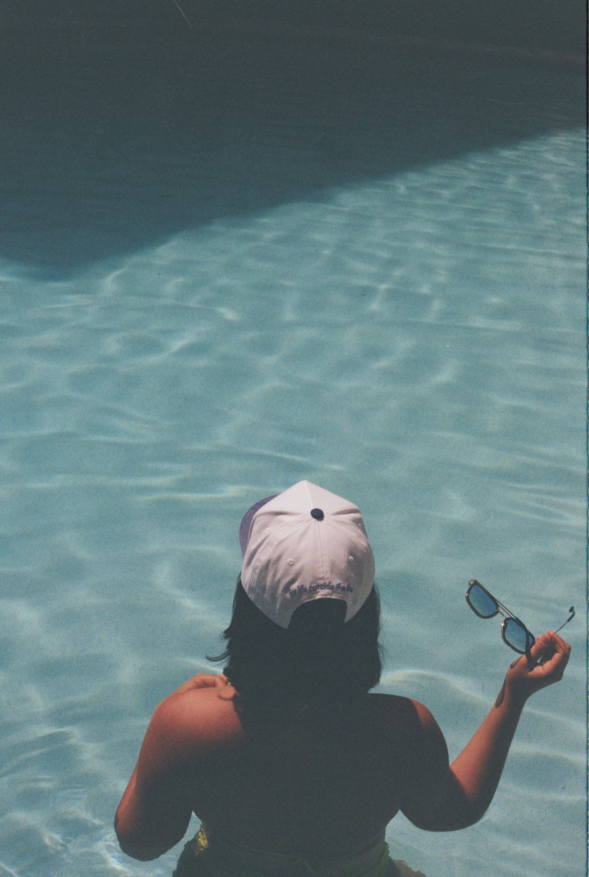 Rear view of a model wearing the Endless Summer Hat in a swimming pool